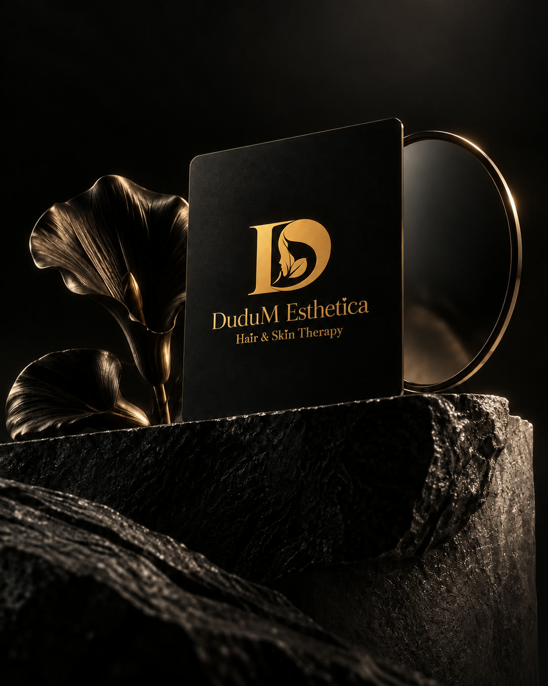 The gold DuduM Esthetica logo on a black card